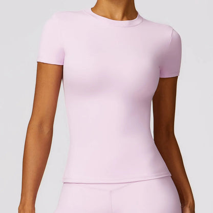 Elevate your fitness wardrobe with the NCLAGEN Short Sleeve T-Shirt in a chic pastel pink hue. Crafted from lightweight, breathable nylon, this stylish gym wear ensures maximum comfort during workouts, yoga sessions, or casual outings. The round neck and fitted