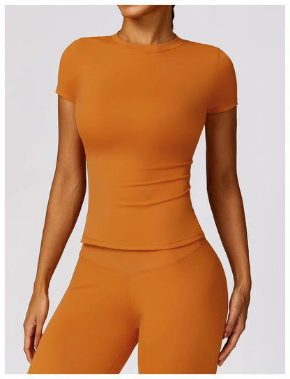 Elevate your activewear collection with the NCLAGEN Short Sleeve T-Shirt in a vibrant orange hue. Crafted from lightweight, breathable nylon, this fitted tee ensures ultimate comfort during workouts, yoga sessions, or casual outings. Its flattering round neck design and